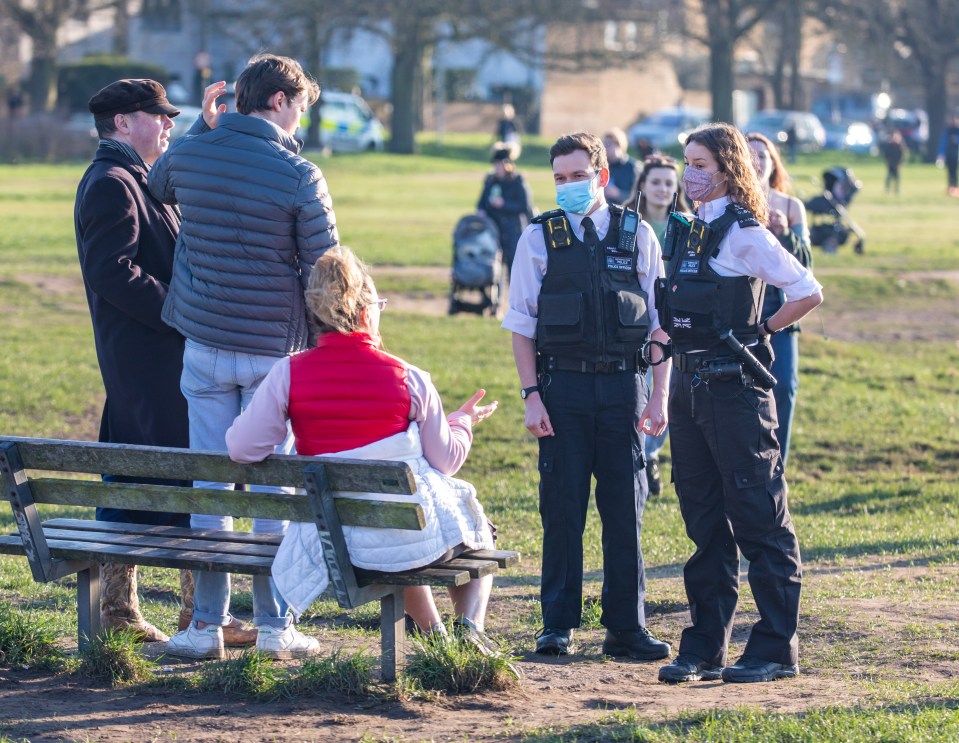 Police speak to some people enjoying the sunshine on Wimbledon Common, South West London