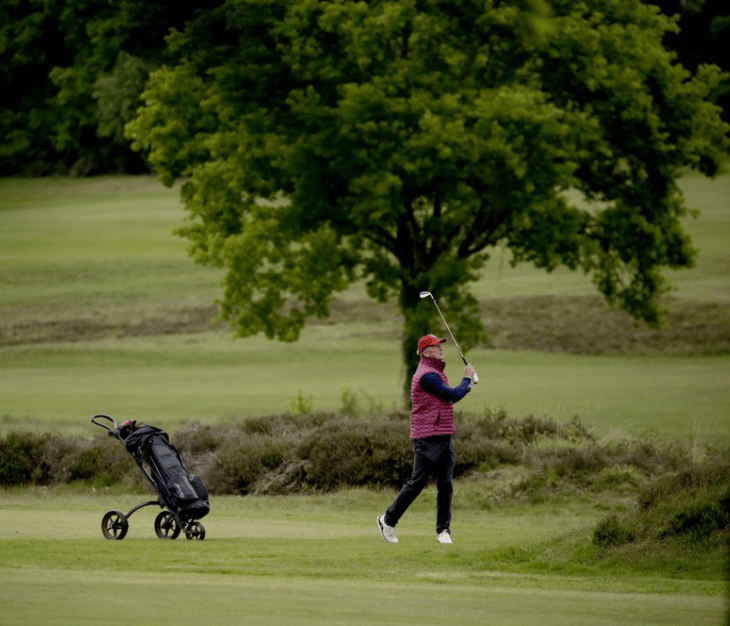 A golfer hits a shot after Sunningdale Golf Club reopened in England, May 2020