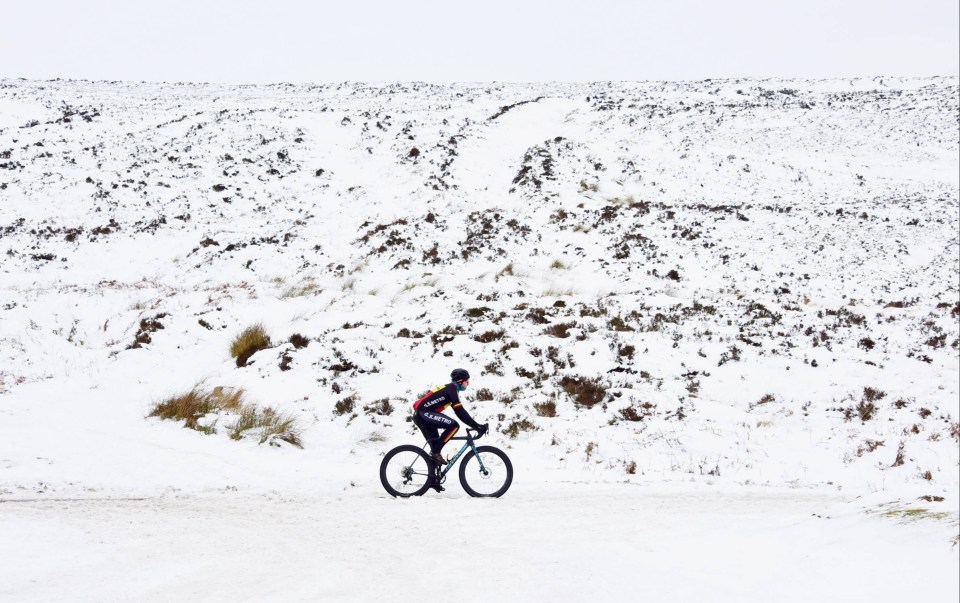 A cyclist makes his way through the snow covered Simsonside Hills near Rothbury