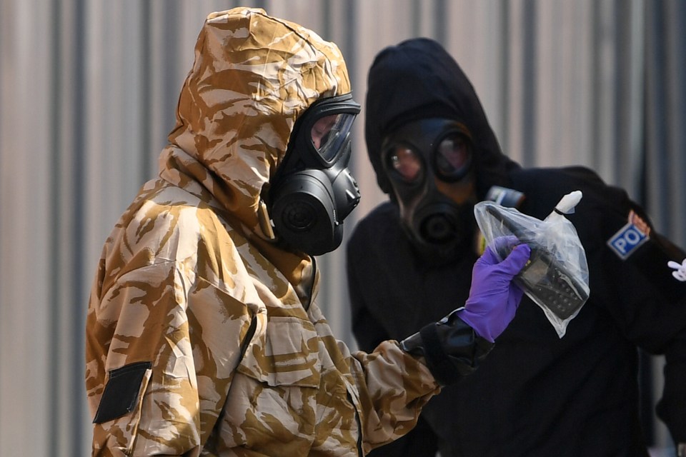 An investigator in Salisbury wears a camouflaged protective suit, gloves and gas mask while working with police after a man and woman were found unconscious as a result of the nerve agent Novichok