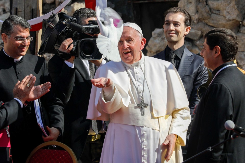 Pope Francis releases a dove during a prayer for war victims in Mosul's Old City