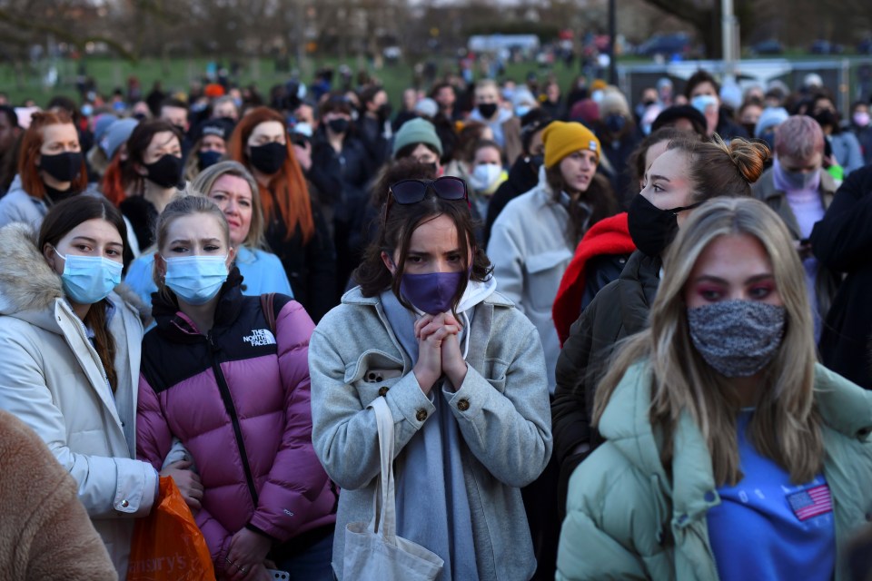 People gather at a memorial site at the Bandstand