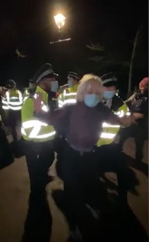 A Met Police officer shoves a woman to the ground