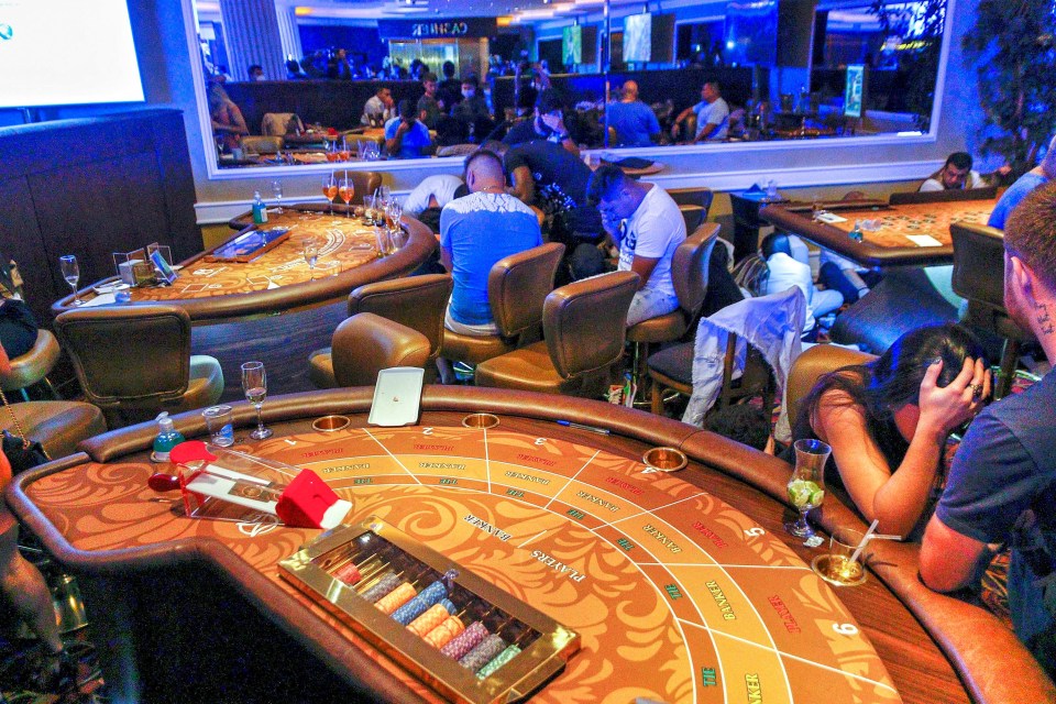 Gamblers hid under the tables after police swooped on the underground casino