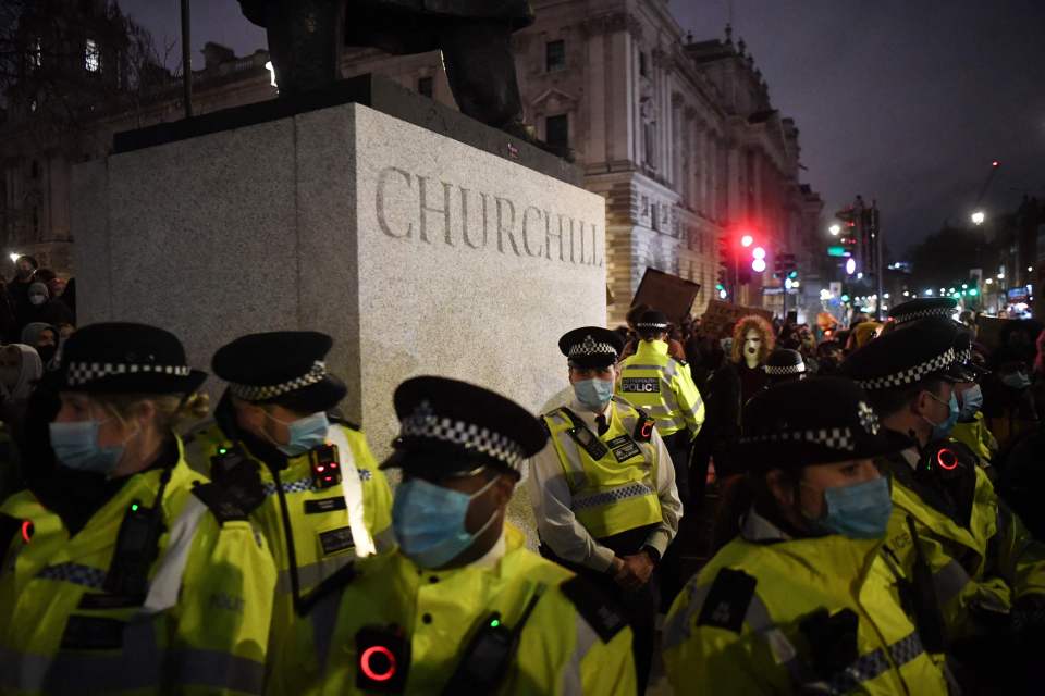 Met Police officers guard the statue during protests last night