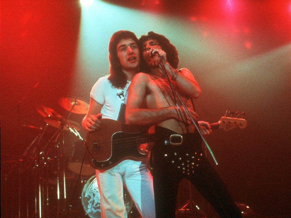 Deacon on stage with Freddie Mercury