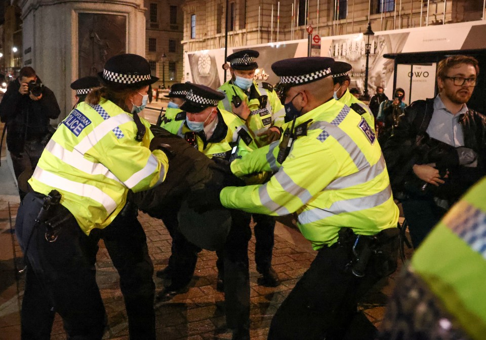 Police officers detain a man during the protests