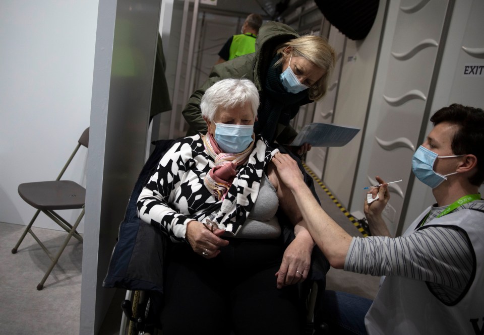 A woman receives a dose of the AstraZeneca COVID-19 vaccine at the Vaccine Village in Antwerp, Belgium