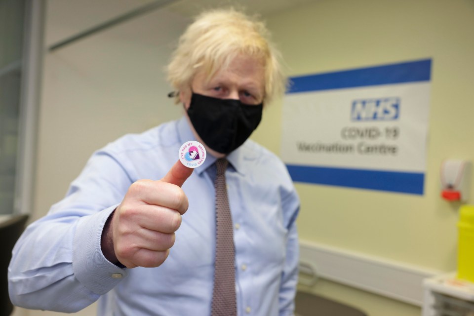 The PM holds up a sticker confirming he has had his jab