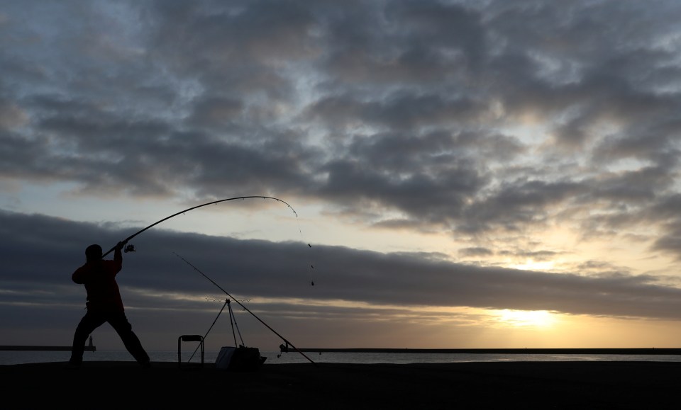 A fisherman casts off at the Herd Groyne Lighthouse pier in South Shields, County Durham