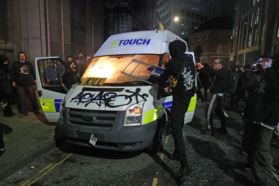 Protesters set fire to a vandalised police van during 'disgusting scenes'