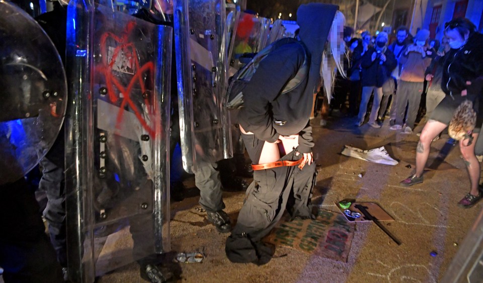 A woman is seen urinating on police at the Kill The Bill riot in Bristol last night