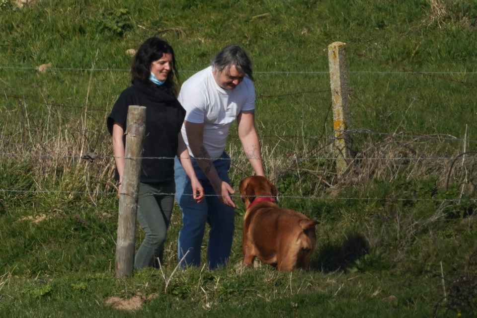 Pete fusses over his dog on a walk with his girlfriend Katia in the French countryside