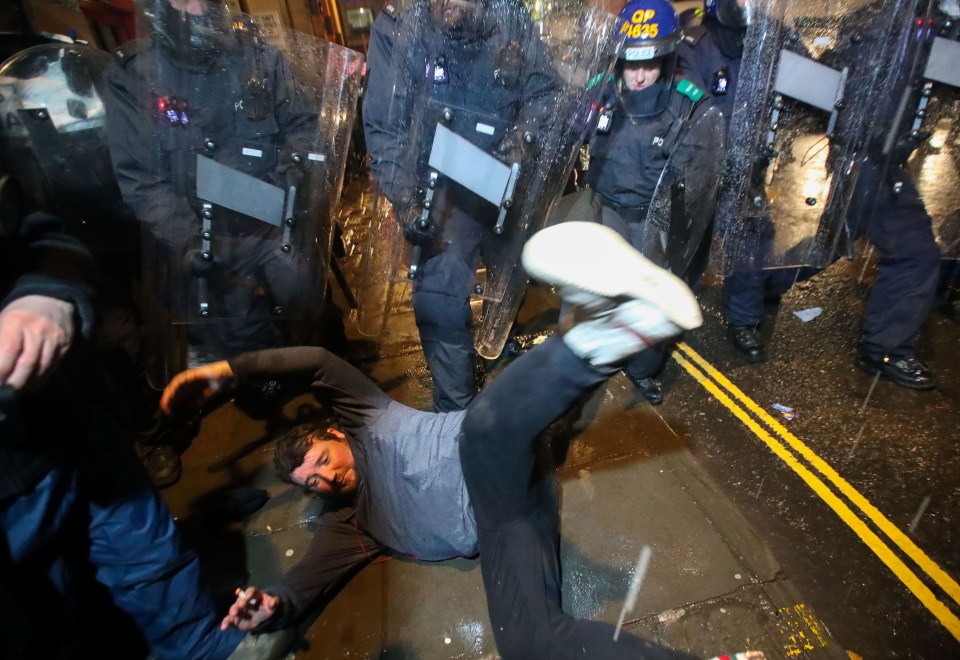 A demonstrator falls during a clash with police officers at a protest against a newly proposed policing bill