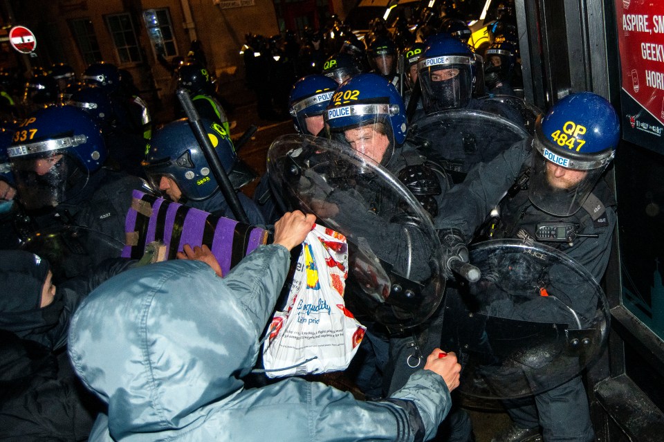 Riot police and protesters clash