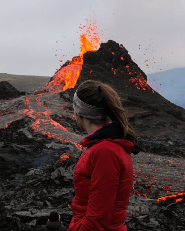 A woman poses near the volcano