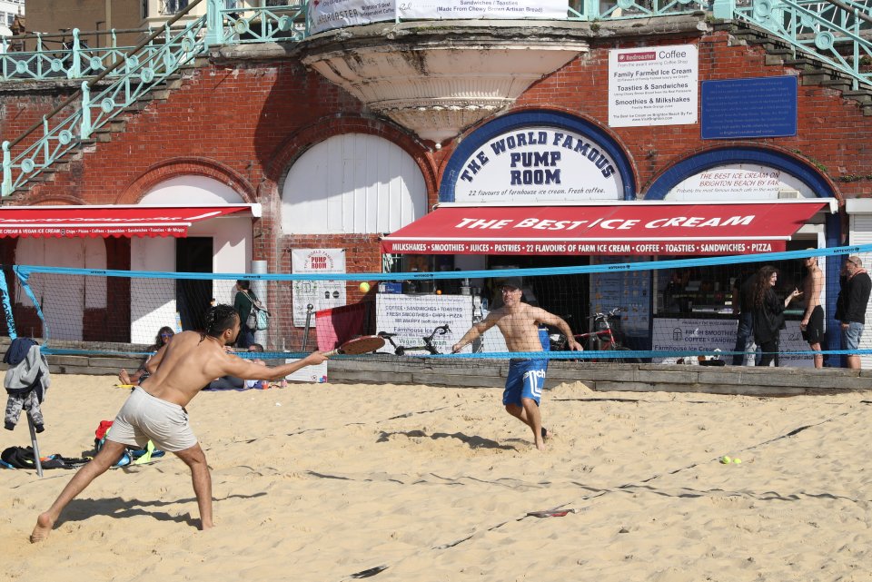 Visitors enjoy the warm sand and sunny weather in Brighton