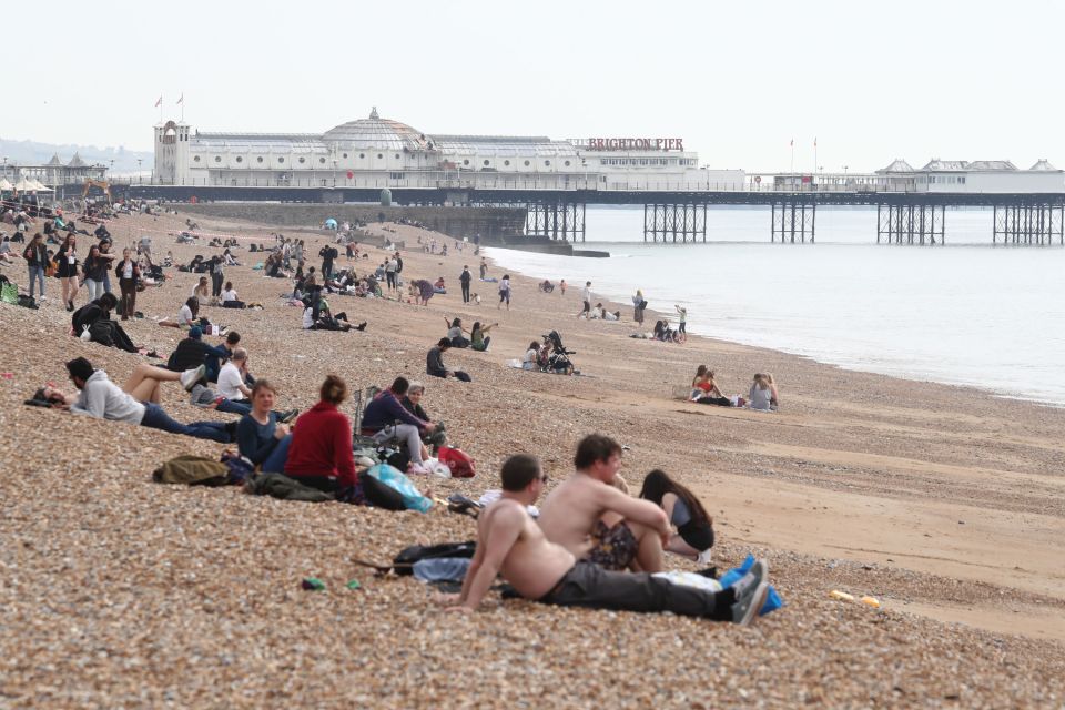 People enjoy the warm weather at Brighton Beach, East Sussex