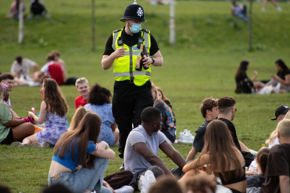 Officers can be seen removing beer bottles from people in the park in Nottingham