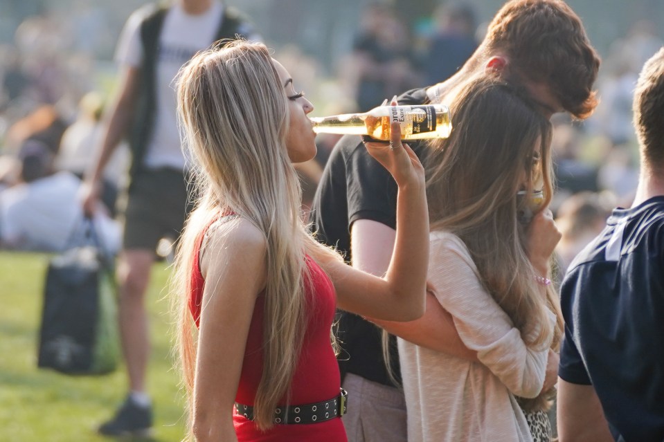 A woman enjoys a beer in the warm weather this evening in Leeds