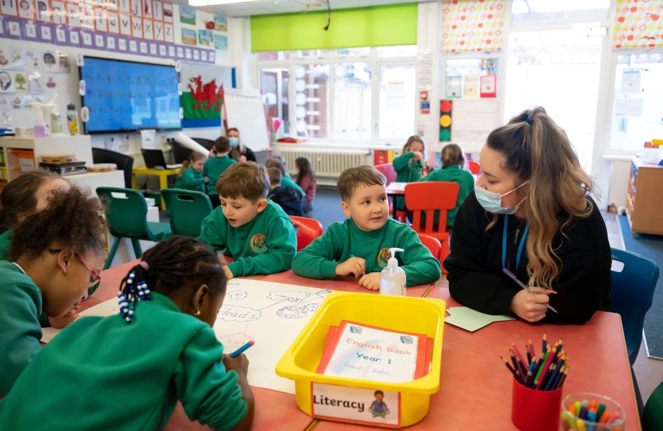 A teacher wearing a face mask speaks to children during a lesson at Bryn Hafod Primary School, Wales