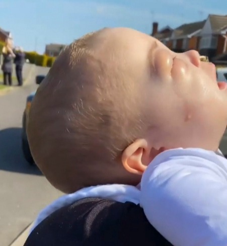 The adorable eight-month-old was held close to her dad's chest during the tribute