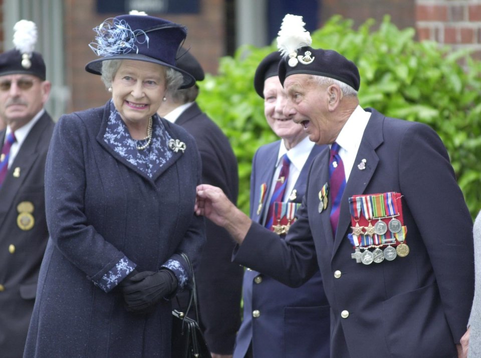 D-Day hero John Bellis gives the Queen a nudge on the arm during a visit to an Army barracks in Wrexham in 2002