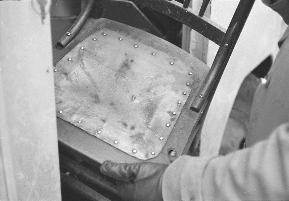 A chair covered in human skin is removed from the house