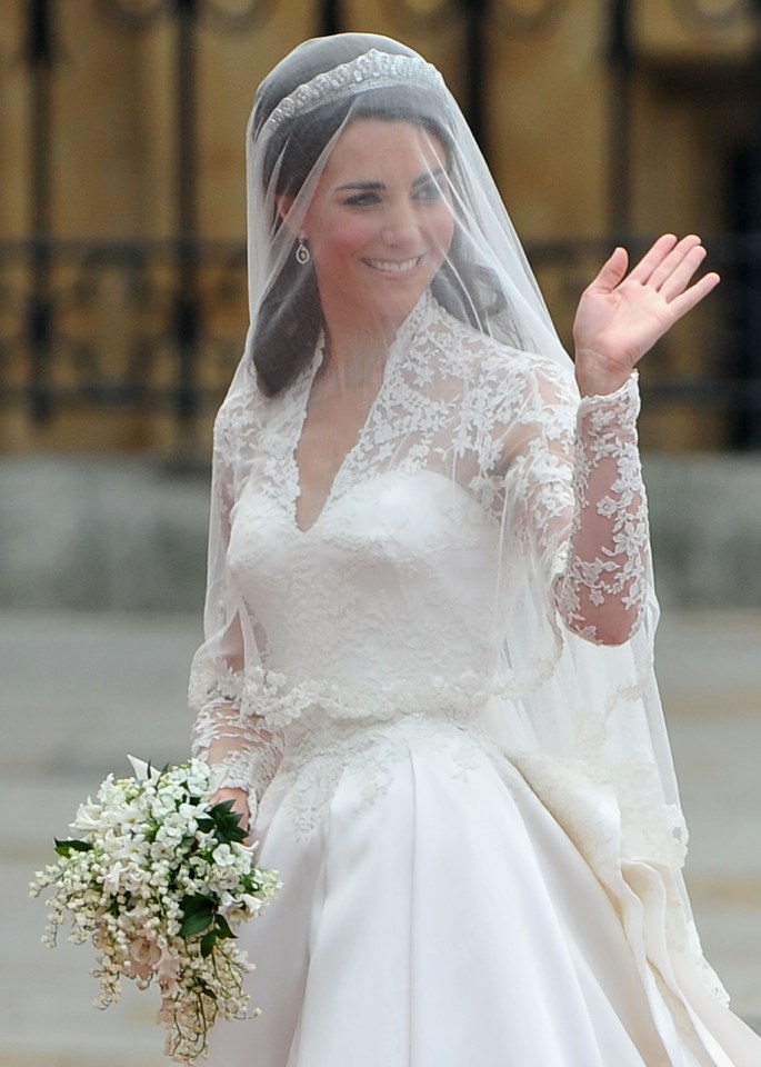 Radiant . . .  Kate beams from under veil as she waves to the crowds