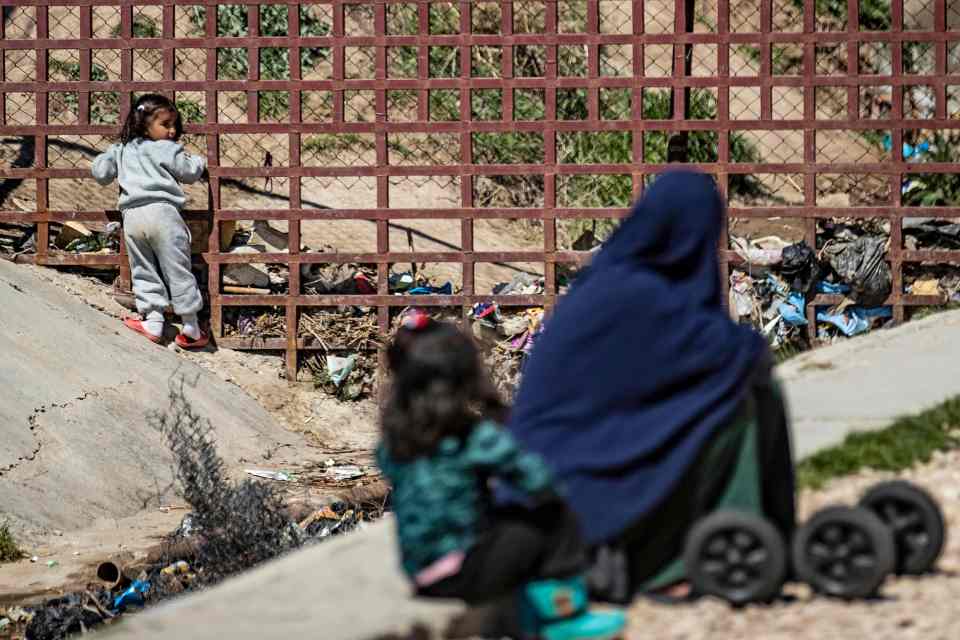 A woman sits with her child on the ground at Camp Roj (file image)