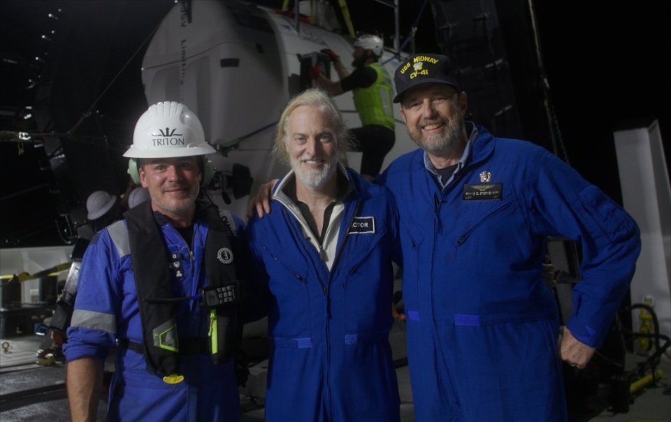 Victor Vescovo (centre) piloted a titanium sub down to the floor of the ocean