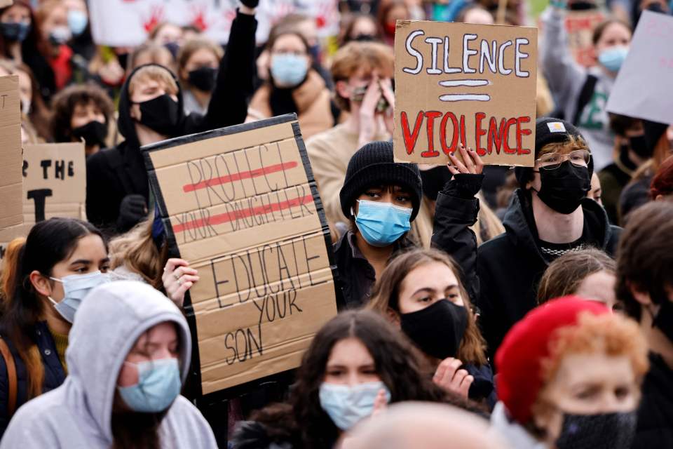 People held signs demanding "educate your son"