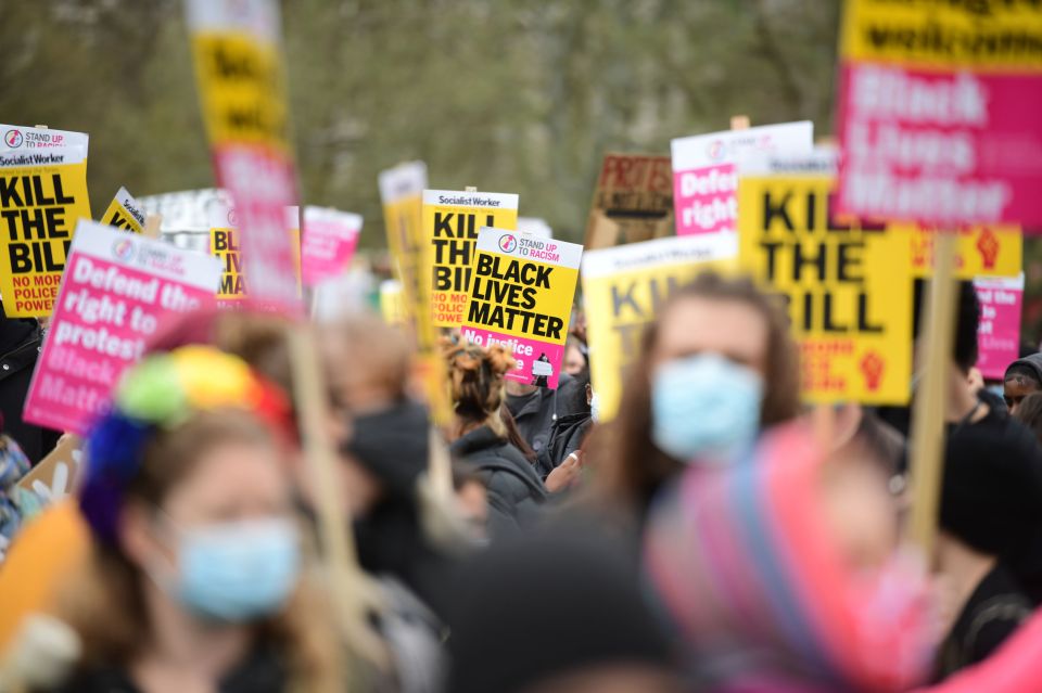 Signs held aloft as people gathered and attempted to socially distance