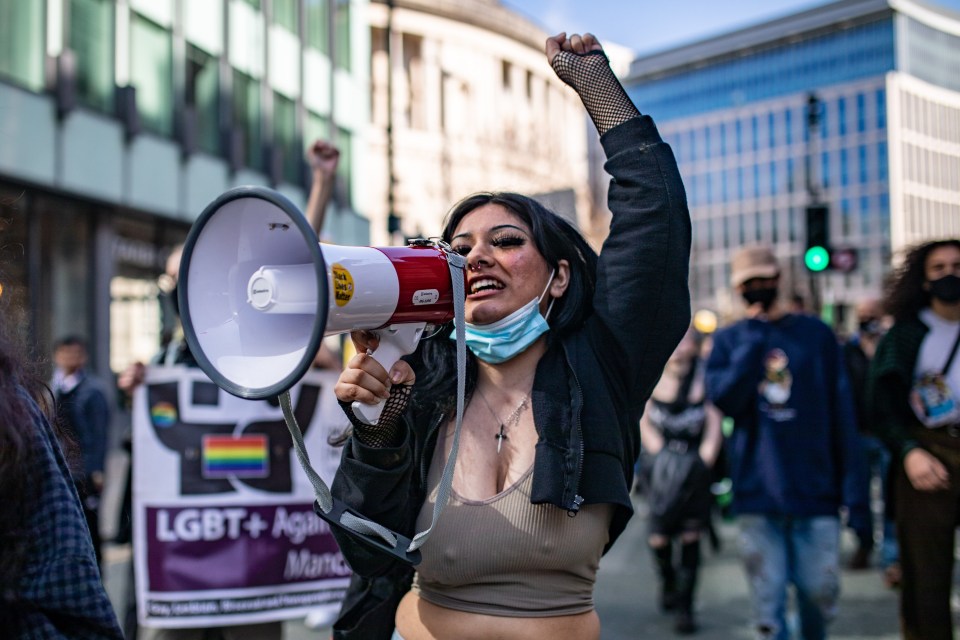 A woman shouting into a megaphone as she protests in Manchester