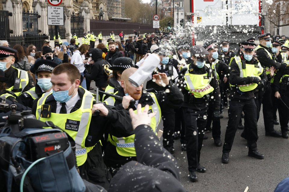 A beer can is thrown at police as scuffles break out in Parliament Square