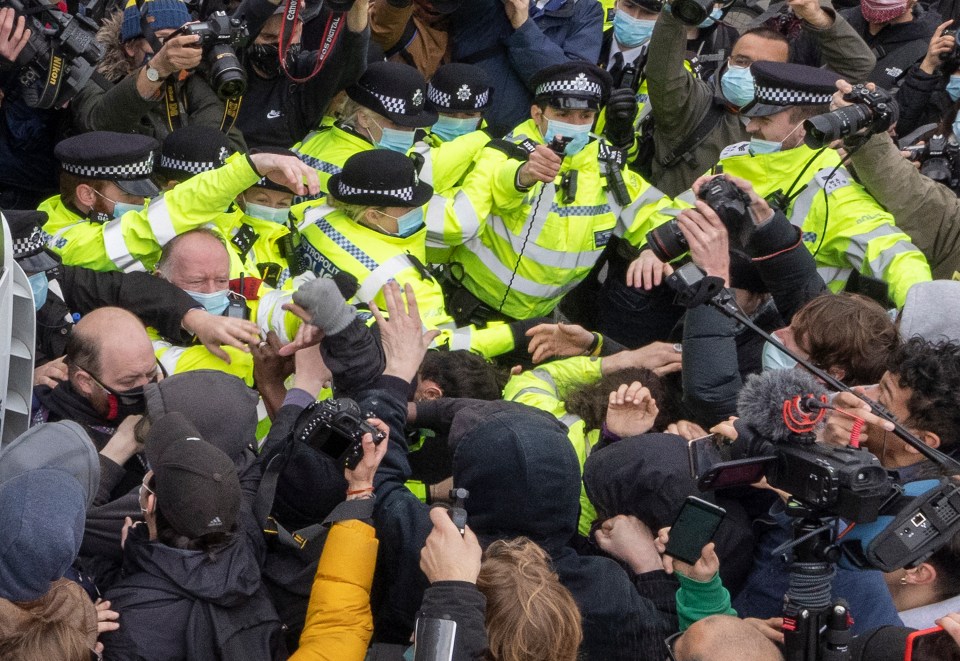 A police officer uses pepper spray as scuffles break out