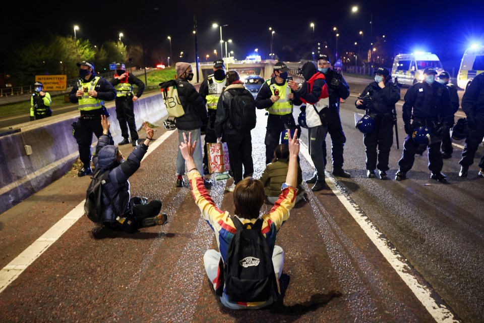 Police officers stand guard as demonstrators block a motorway during a "Kill the Bill" protest in Bristol