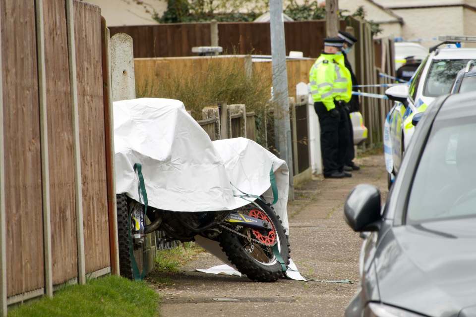 A motorbike is seen covered in a white sheet