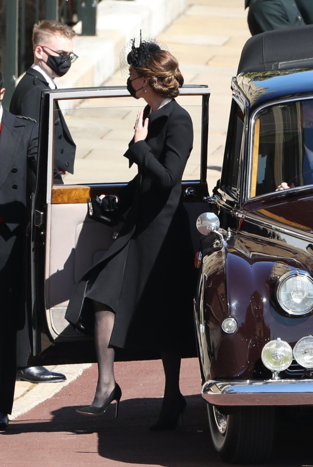 Kate wore a sleek black dress under a midi coat and finished off her look with a set of pearls and a black netted hat