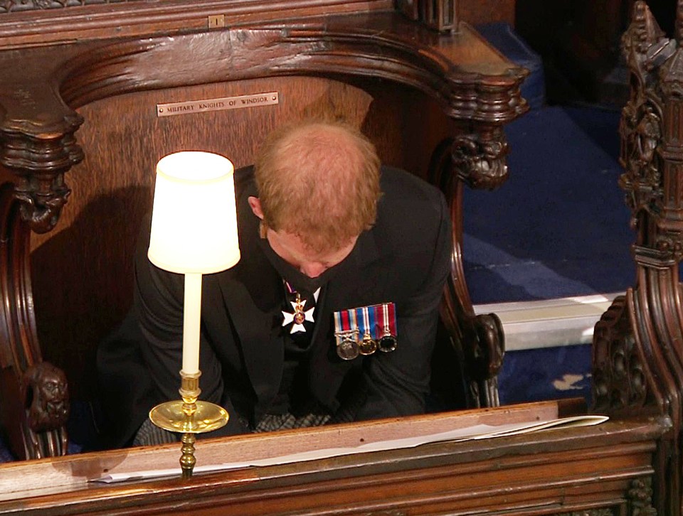 Harry bows his head as he sits alone in the chapel