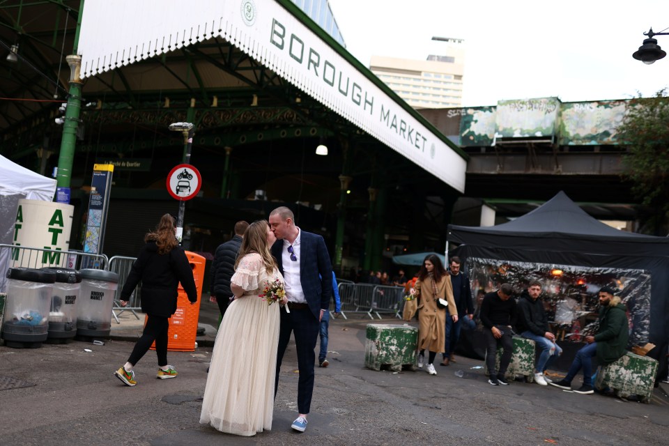 A newly-wed couple kiss in Borough Market