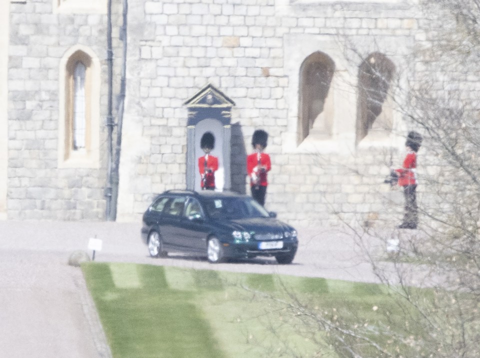 The Queen's car seen leaving Windsor Castle as guardsmen stand to attention