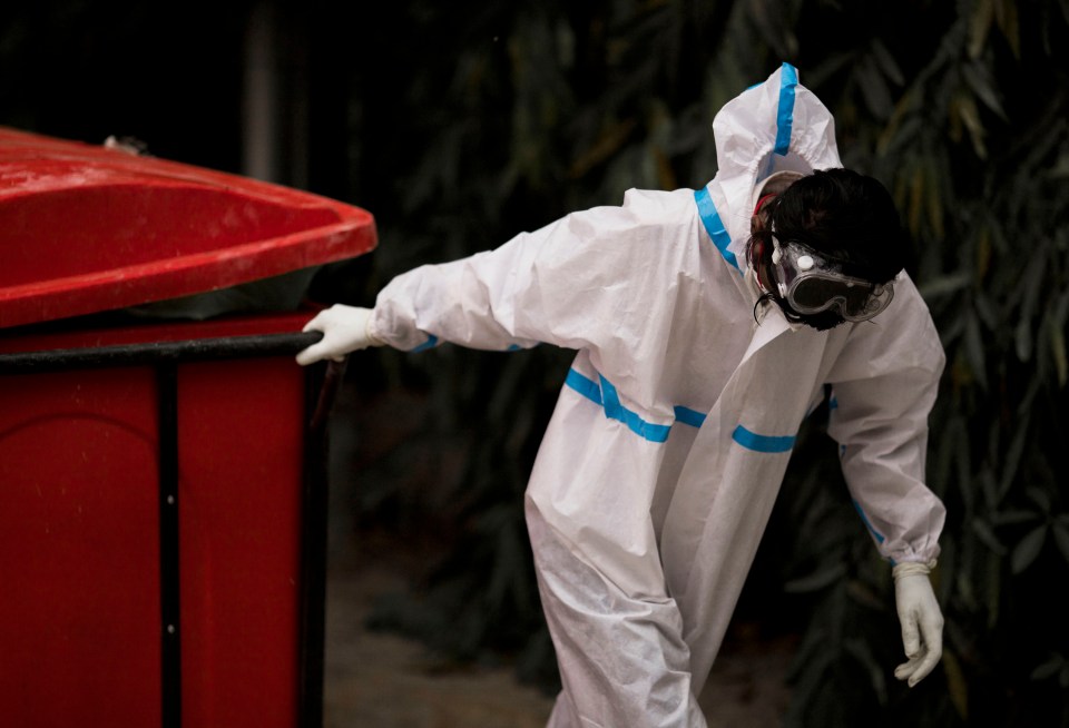 A hospital worker wearing PPE pulls a cart containing Covid-19 waste to be disposed safely at a hospital in New Delhi