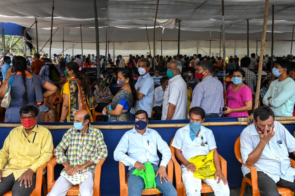 People wait in a queue to receive the coronavirus vaccine at a centre in Mumbai