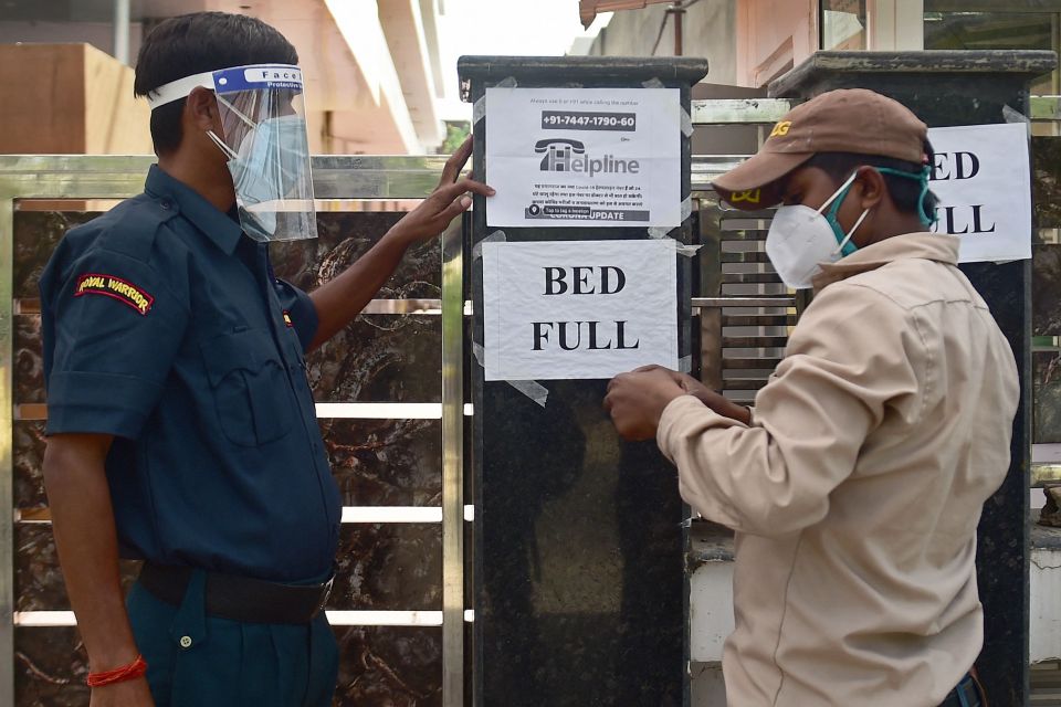 A security guard puts up a notice informing the non-availability of beds in a private hospital in Allahabad