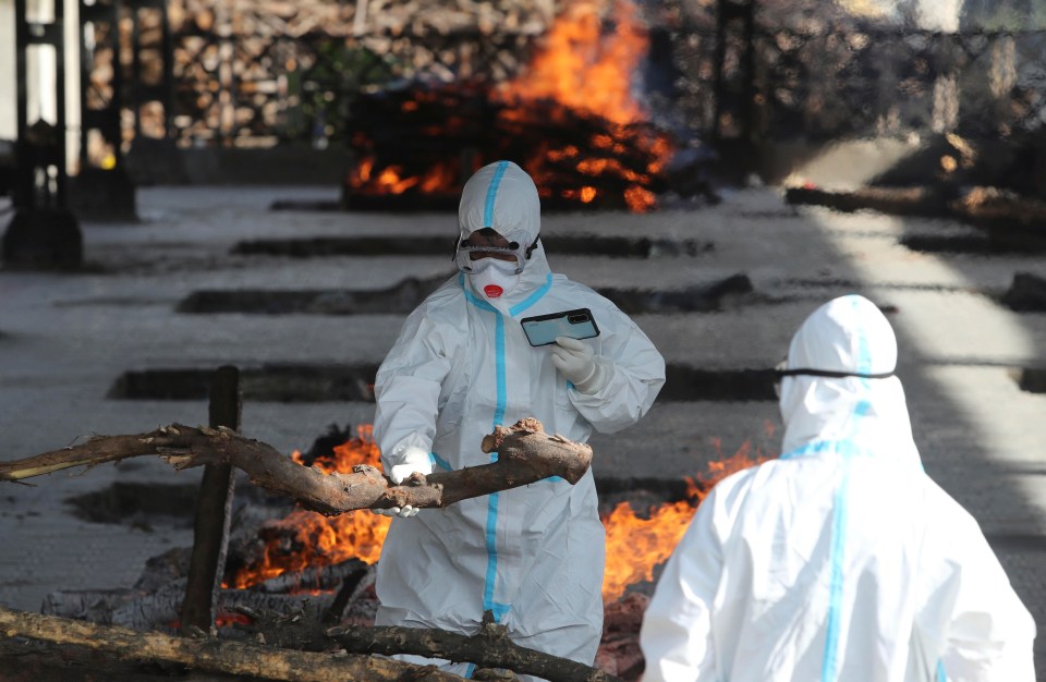 A family member performs the last rites for a Covid victim at a crematorium in Jammu, India