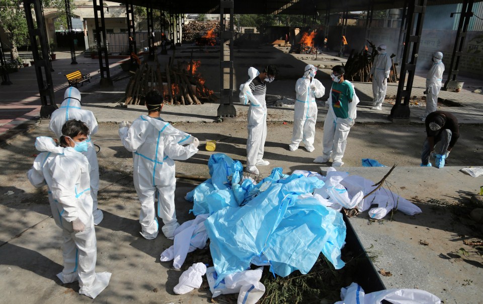 People remove their protective suits at a crematorium in Jammu, India