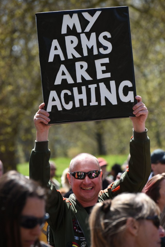 One man holds a sign saying ‘my arms are aching’