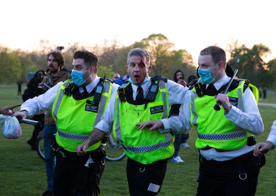 The officer is supported by his colleagues after sustaining head wounds