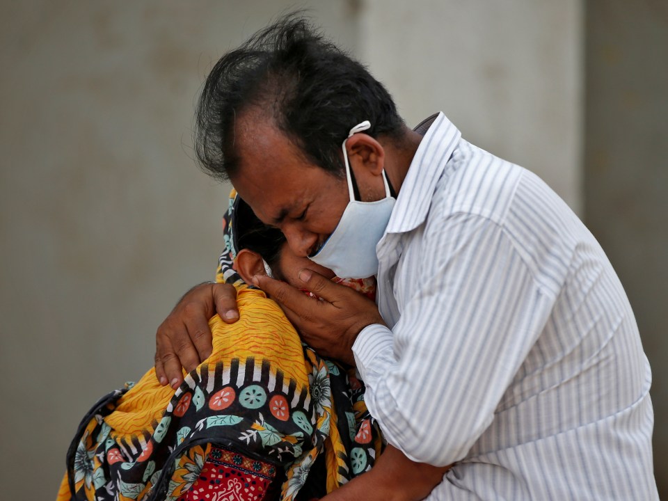 A woman is consoled by her relative after her husband died from Covid